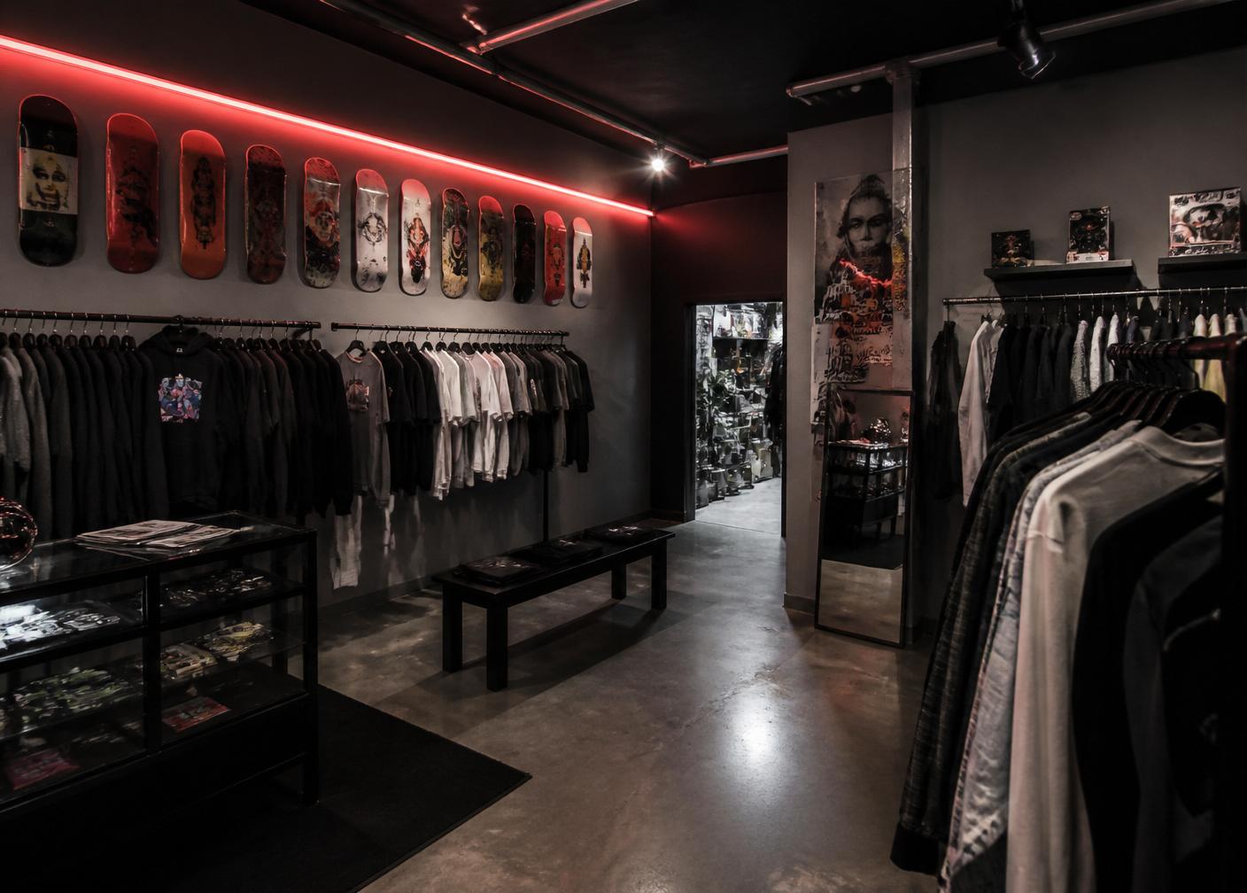 Interior de la tienda BRGD con percheros de ropa y tablas de skate en la pared
